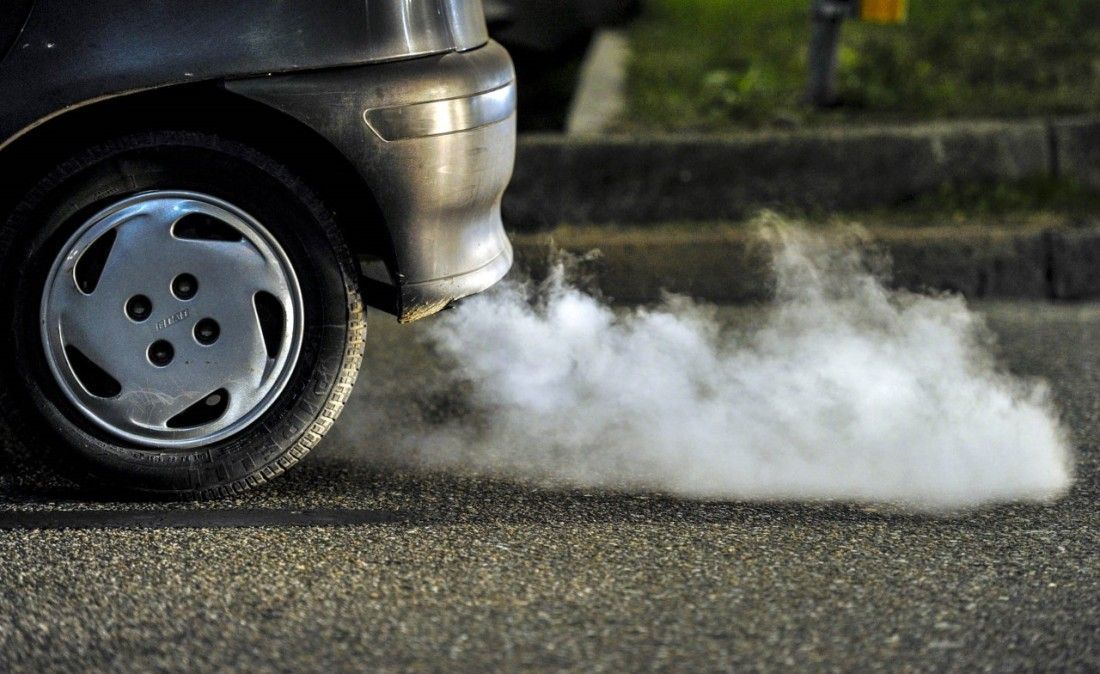 Smoke is coming out of the exhaust pipe of a car.